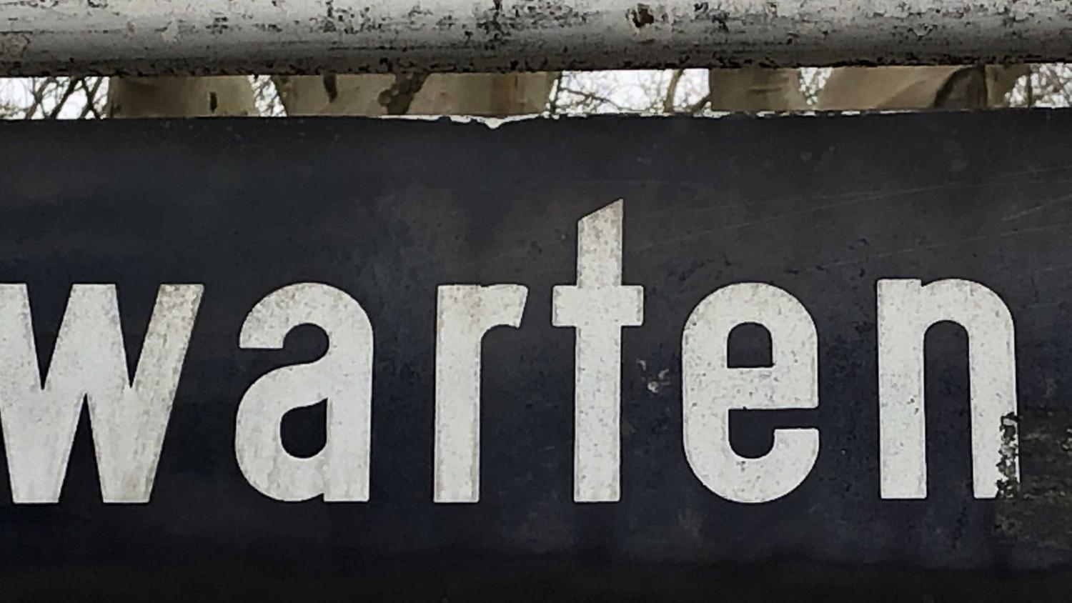 Schild mit Schriftzug 'Warten'