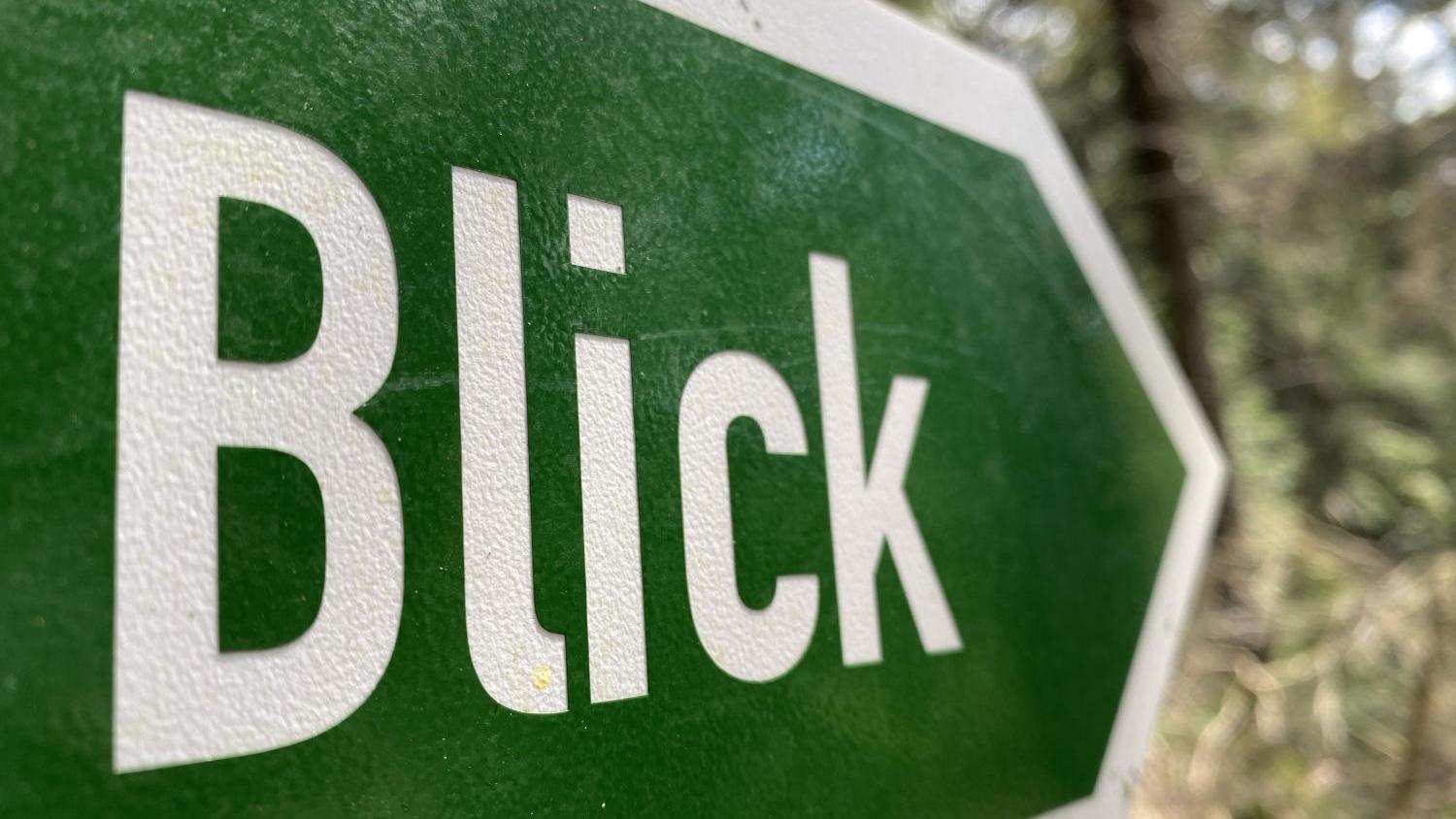 Wegweiser mit Aufschrift 'Blick' -- grünes Schild mit weißem Rand und weißer Schrift -- Form eines nach rechts gerichteten Pfeils