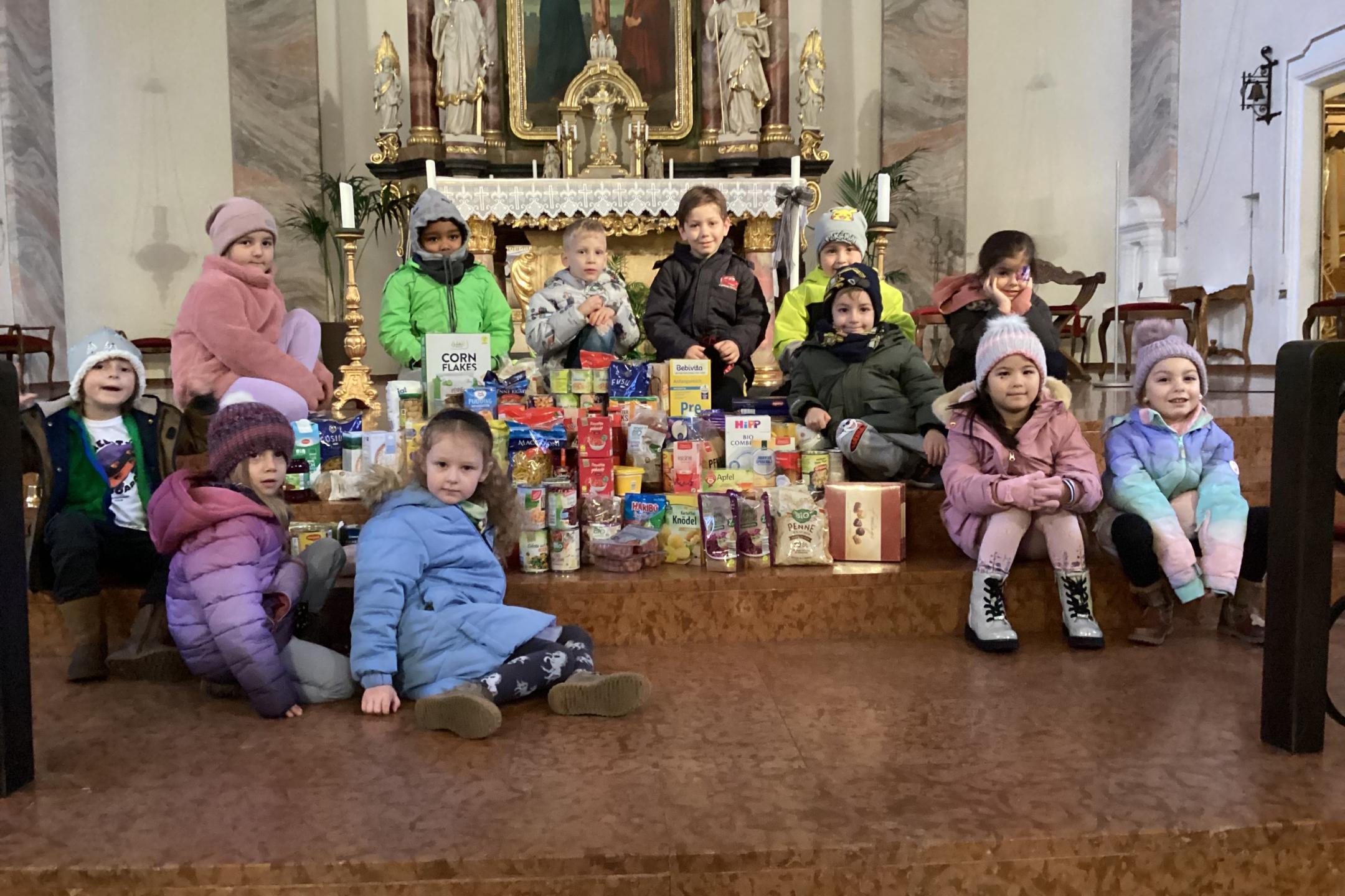 Kinder der KiTa St. Laurentius mit ihrer Spende für Tischlein Deck Dich vor dem Altar der Kirche St. Laurentius