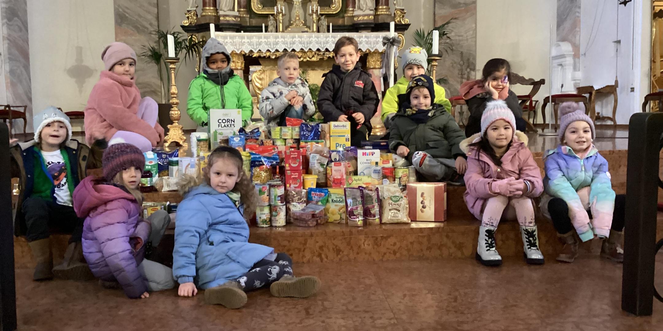 Kinder der KiTa St. Laurentius mit ihrer Spende für Tischlein Deck Dich vor dem Altar der Kirche St. Laurentius